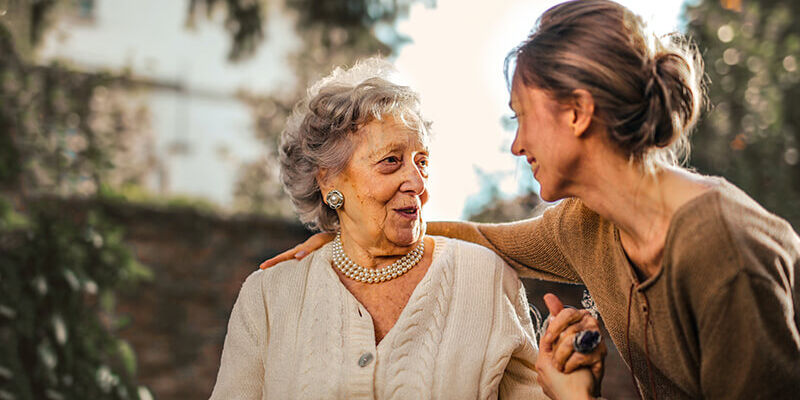 senior citizen holding a womans hand