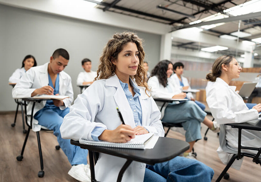 Group of Latin American medical students sitting in the classroom listening to a lecture and taking notes - medical school concepts